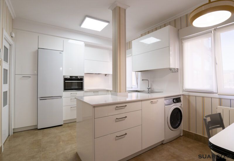 Cocina blanca abierta al salón con península Suarco