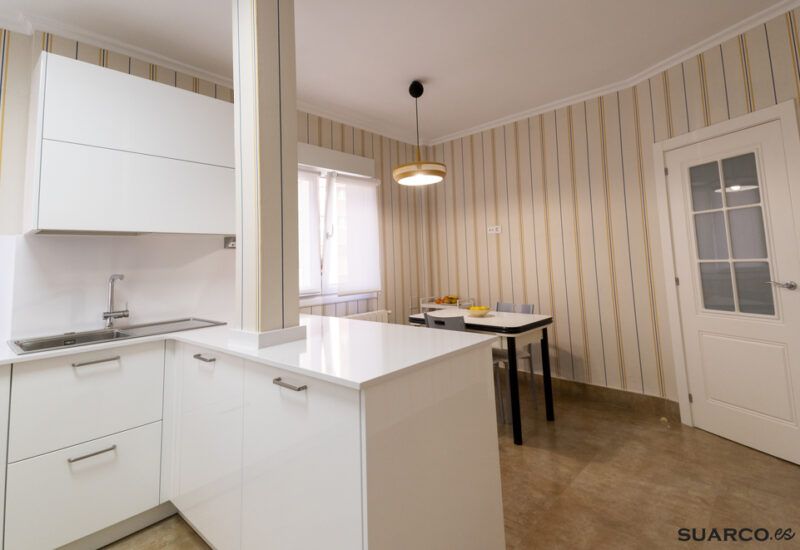 Cocina blanca abierta al salón con península Suarco