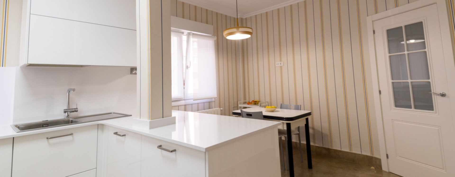 Cocina blanca abierta al salón con península Suarco