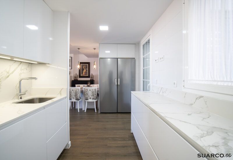 Cocina blanca en forma de U abierta al salón_ Cocinas Suarco