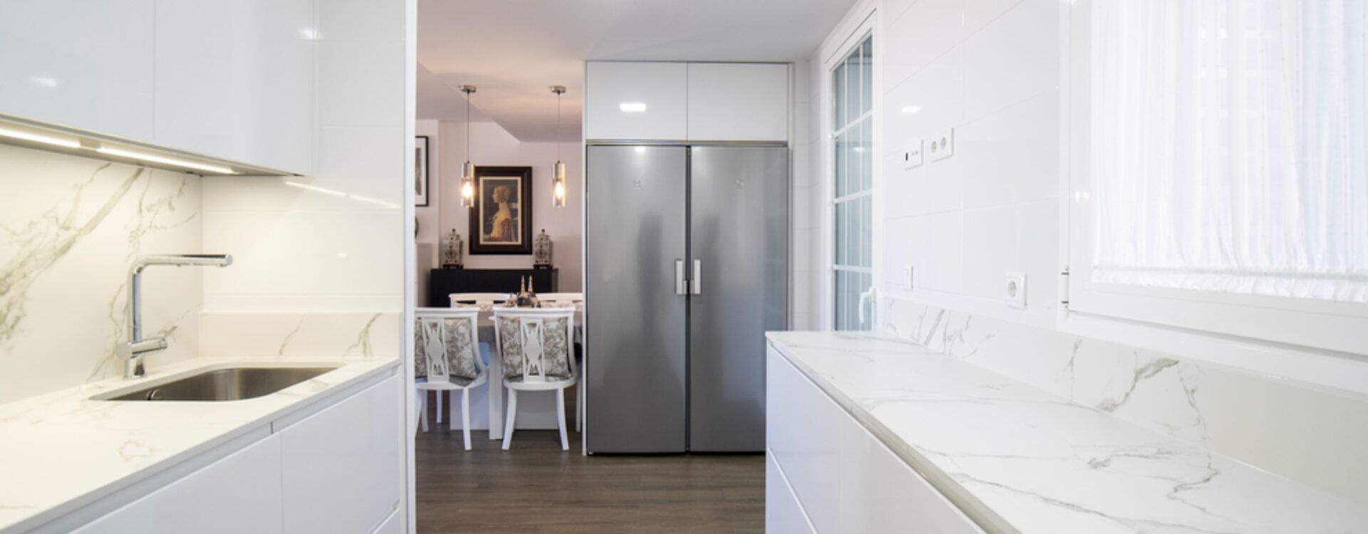 Cocina blanca en forma de U abierta al salón_ Cocinas Suarco