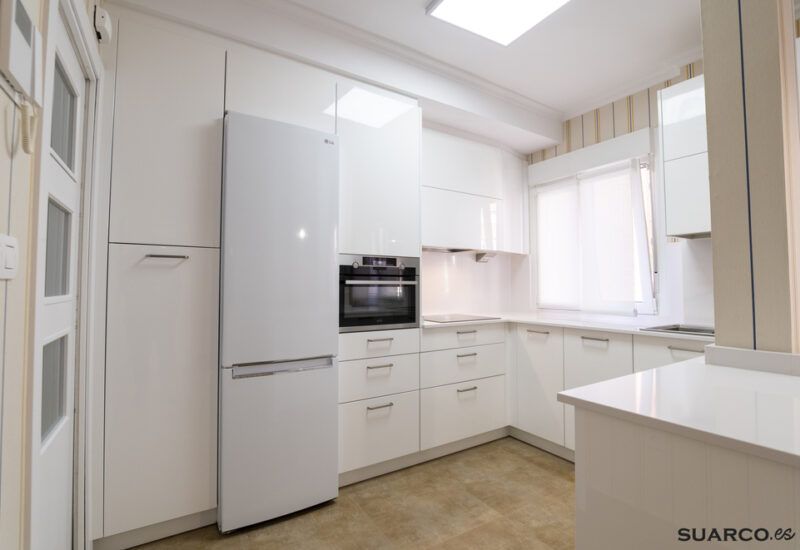 Cocina blanca abierta al salón con península Suarco