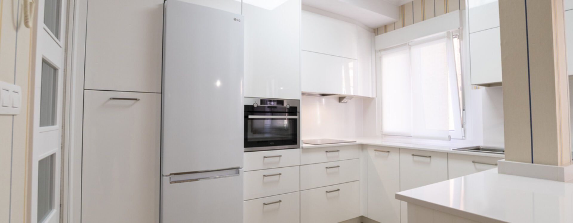 Cocina blanca abierta al salón con península Suarco