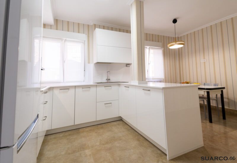 Cocina blanca abierta al salón con península Suarco