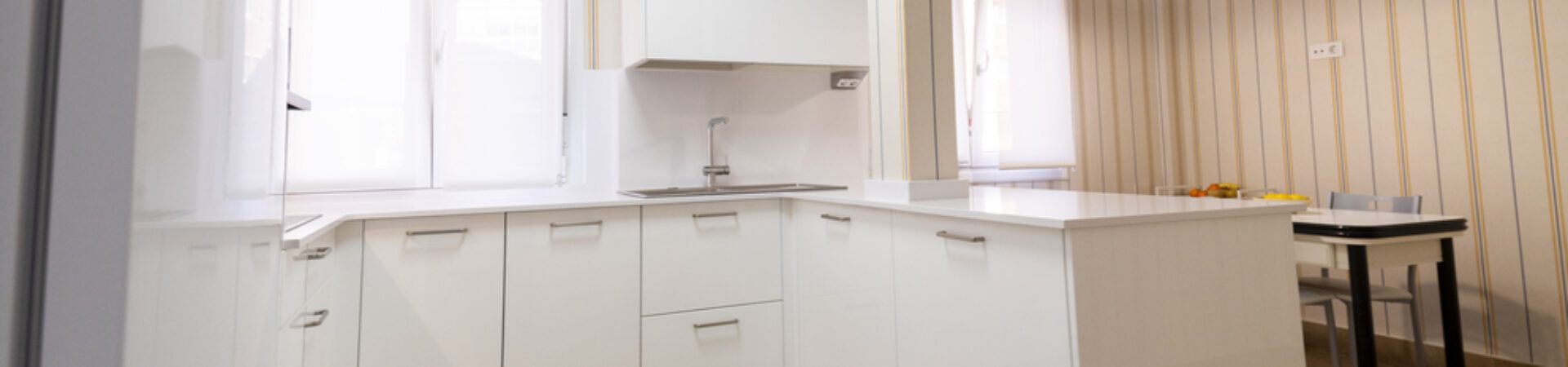 Cocina blanca abierta al salón con península Suarco