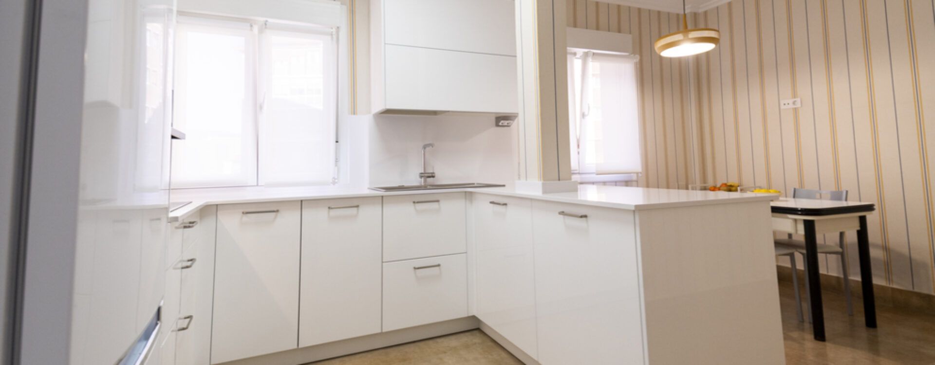 Cocina blanca abierta al salón con península Suarco