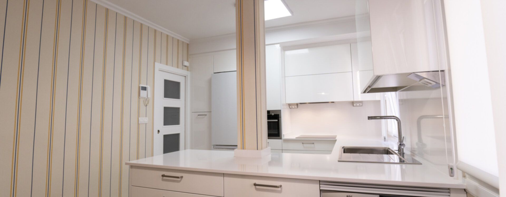 Cocina blanca abierta al salón con península Suarco