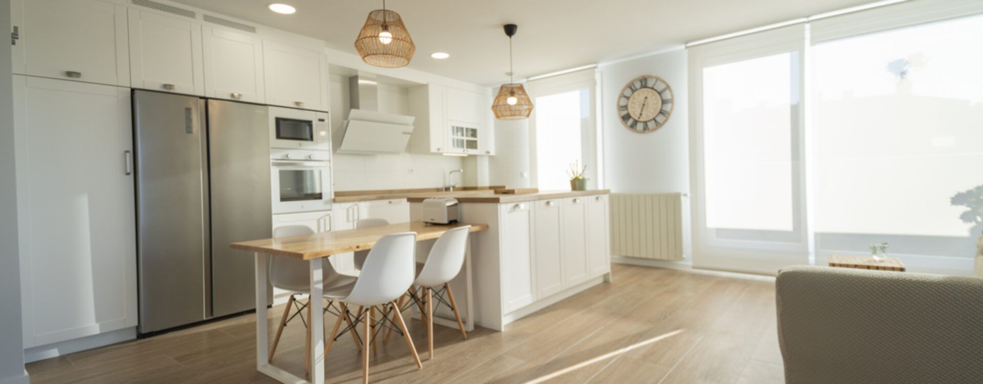 Cocina blanca con isla y encimera de madera. Cocinas Suarco
