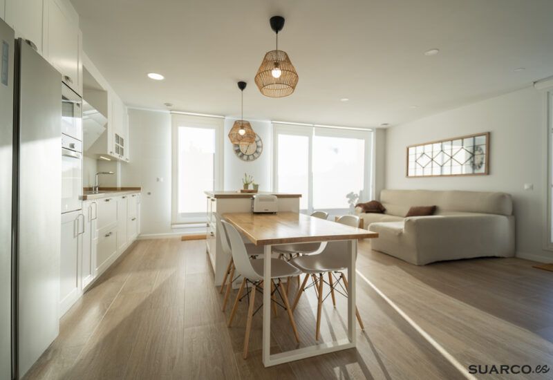 Cocina blanca con isla y encimera de madera. Cocinas Suarco