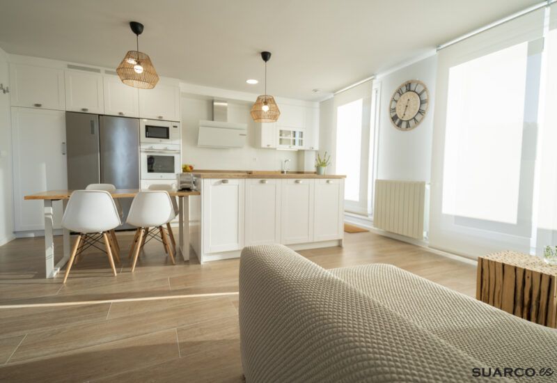 Cocina blanca con isla y encimera de madera. Cocinas Suarco