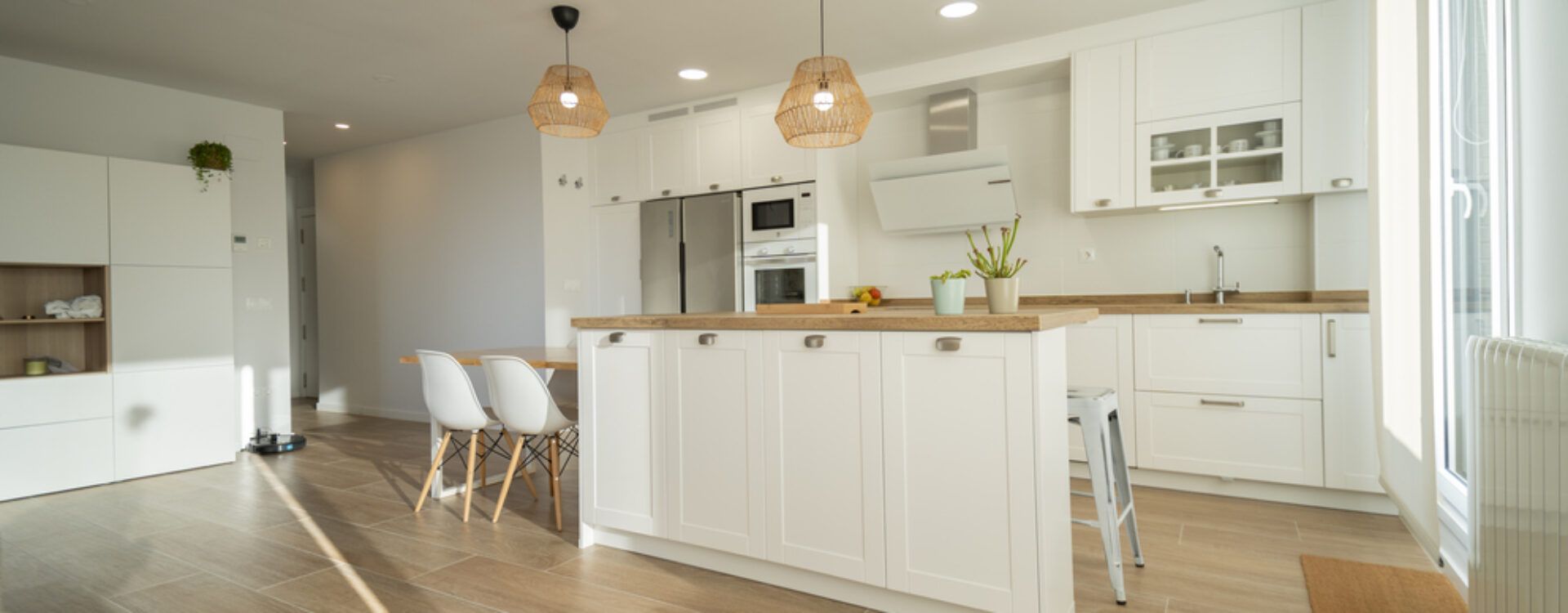 Cocina blanca con isla y encimera de madera. Cocinas Suarco