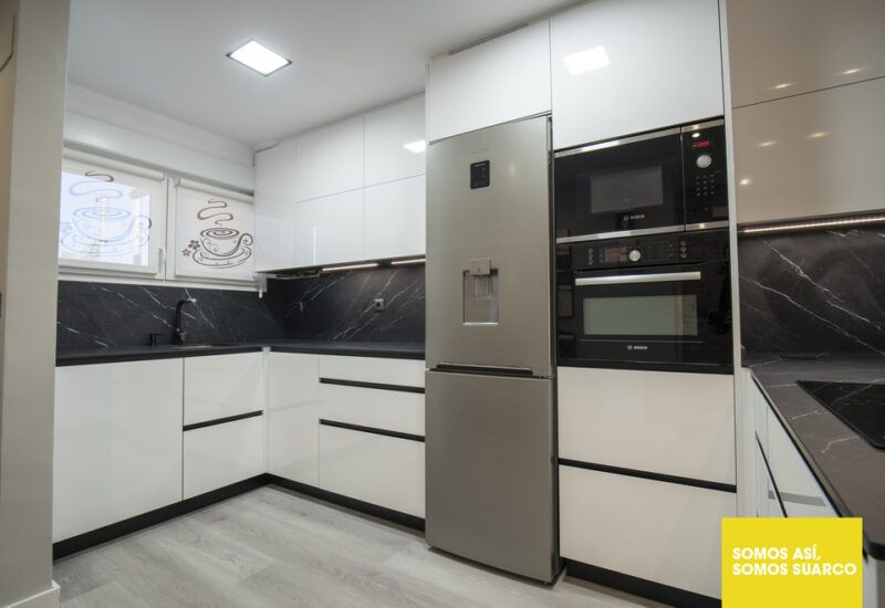 Cocina moderna blanca abierta al salón Suarco