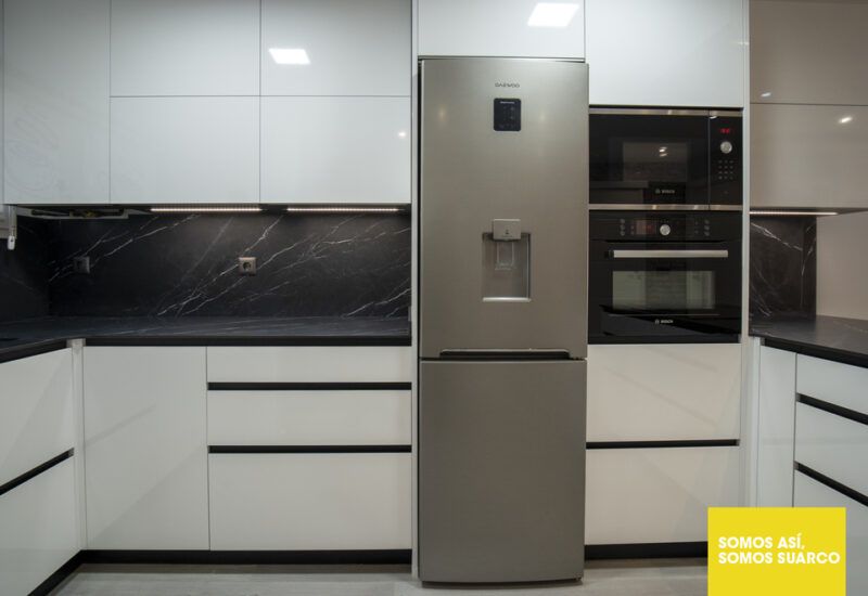 Cocina moderna blanca abierta al salón Suarco