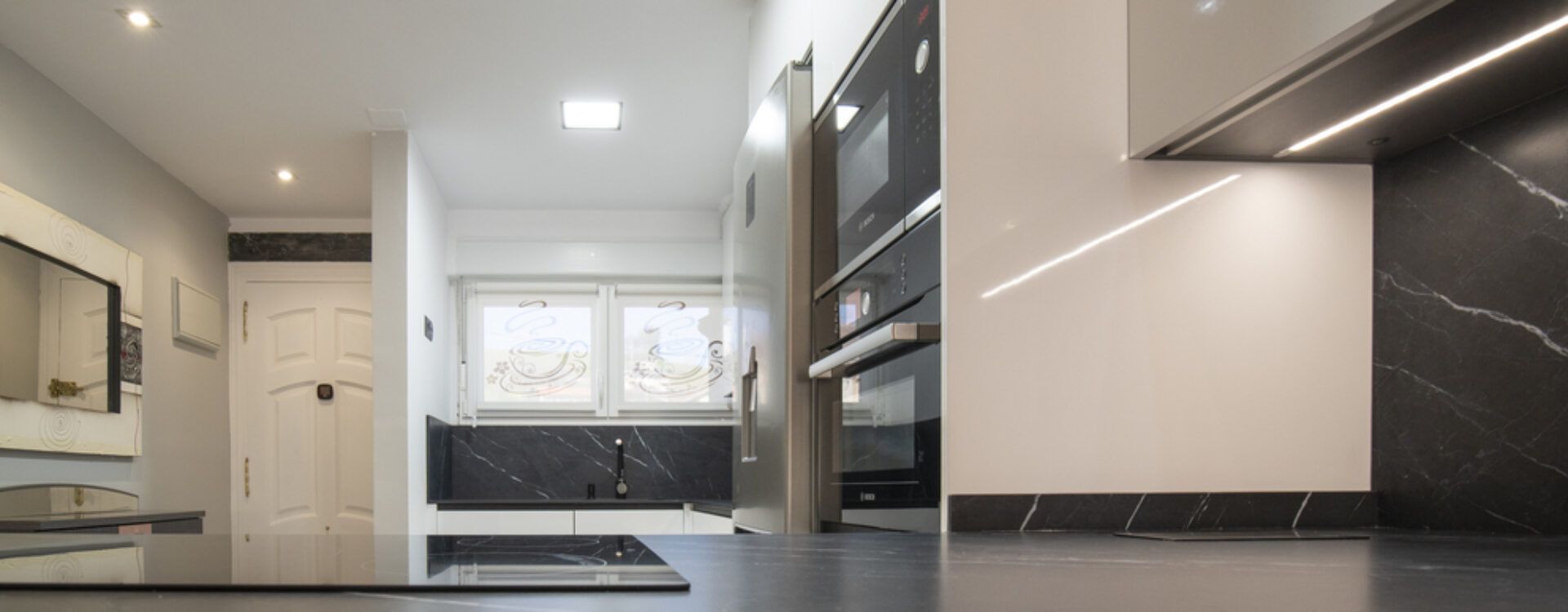 Cocina moderna blanca abierta al salón Suarco