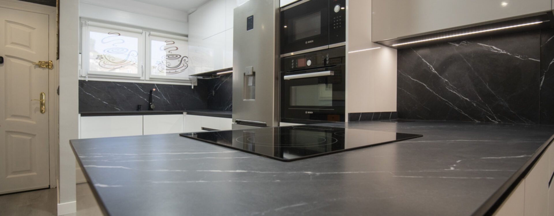 Cocina moderna blanca abierta al salón Suarco